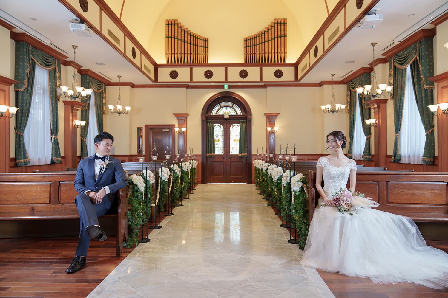 チャペルのバージンロードに座る新郎新婦